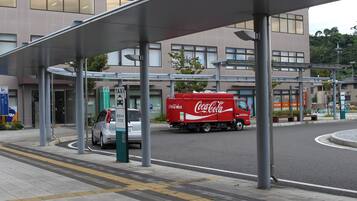 Un edificio moderno con un acceso cubierto, un camión de Coca-Cola y una zona de estacionamiento.