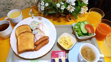 A breakfast tray with toast, sausages, scrambled eggs, a salad, and coffee.