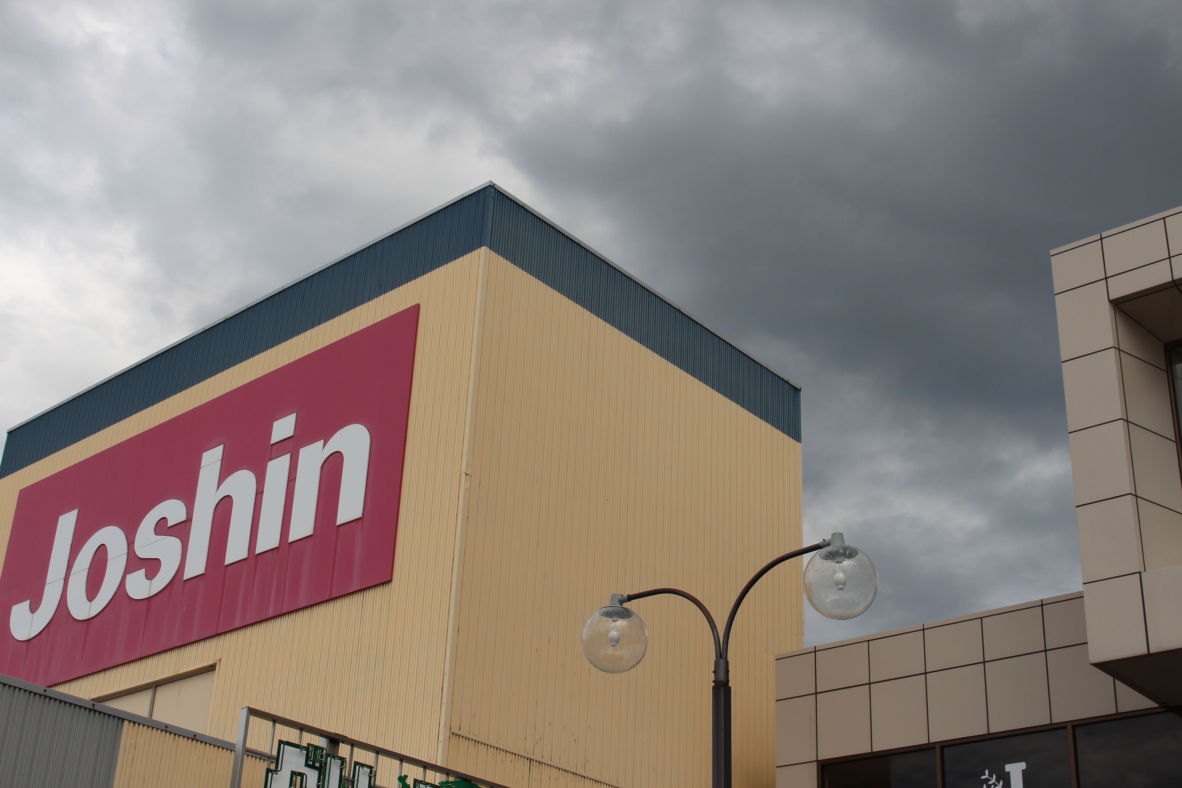 A building with a large 'Joshin' sign on its facade.