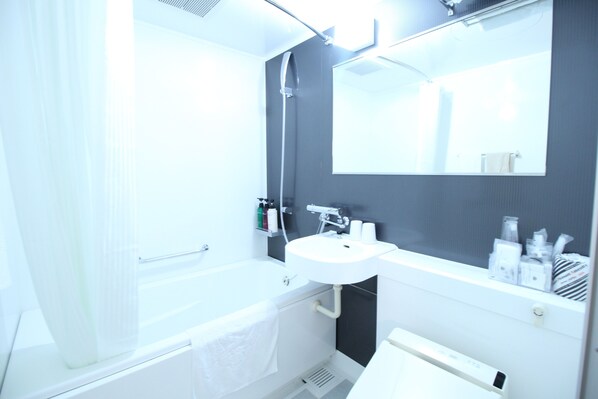 Un baño moderno con bañera, lavamanos y un espejo grande.