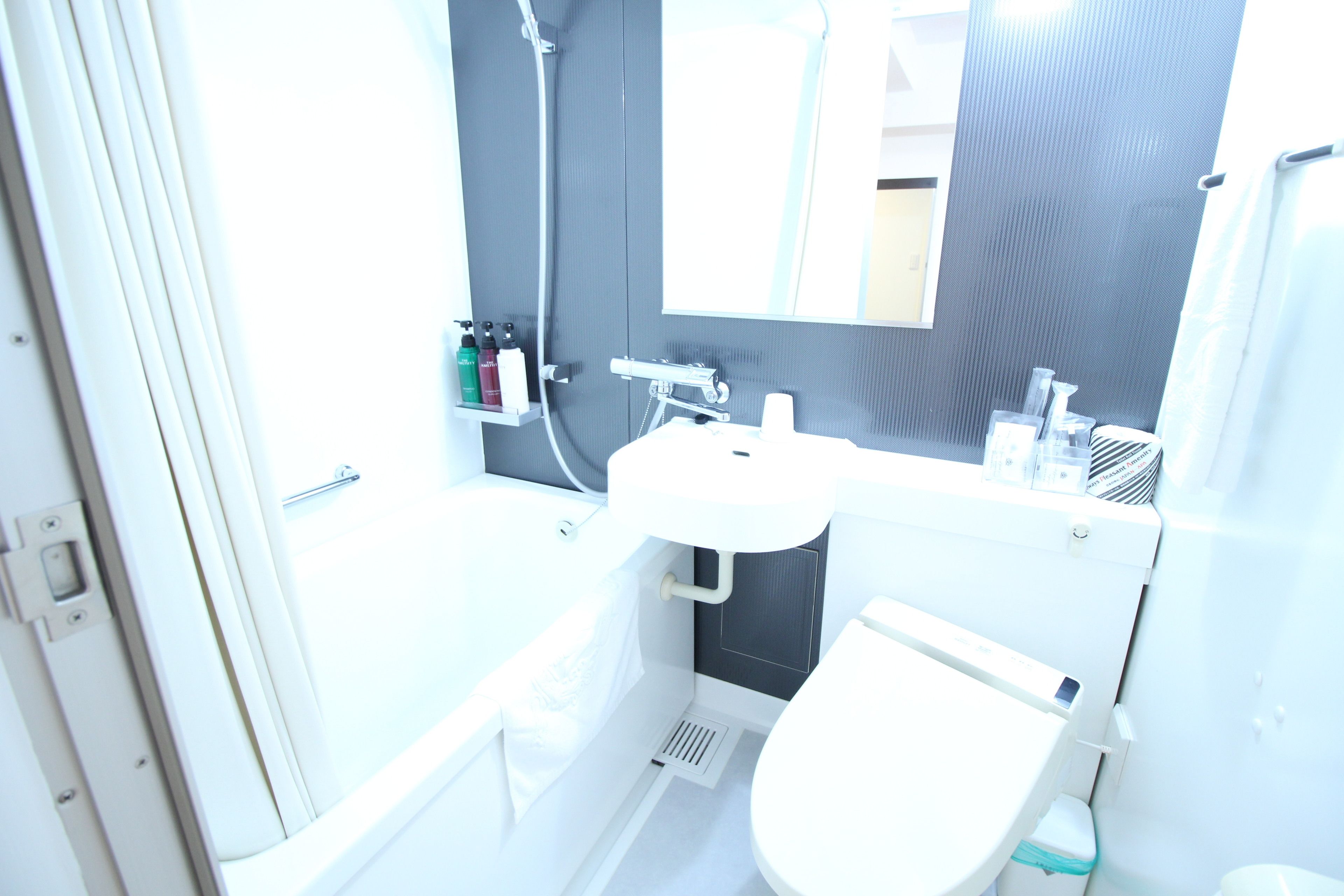 Et moderne badeværelse med en hvid vask, toilet og brusebad.