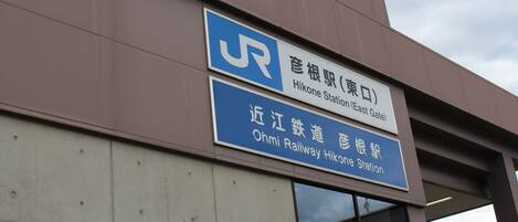 A building with signage indicating it is the Hikone Station (East Gate) and the Ohmi Railway Hikone Station.