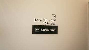 A sign indicating room numbers 601-604 and 605-608, and a restaurant sign with a left-pointing arrow.