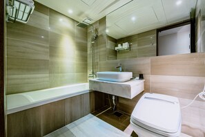 Een moderne badkamer met een bad, een wastafel en een douche.