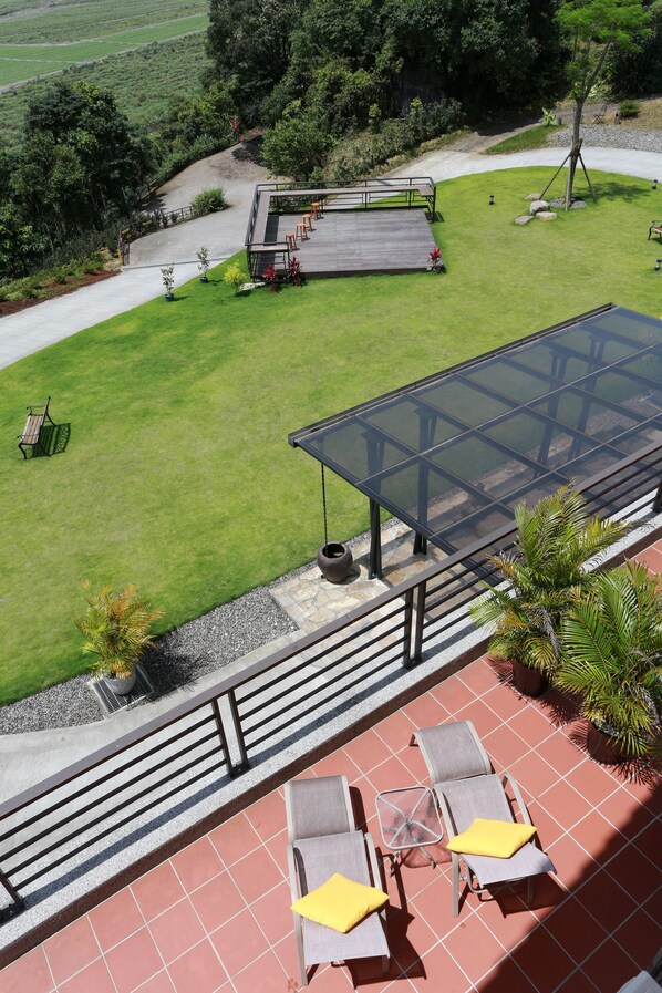 Terraço no telhado com estrutura de vidro, mobiliário para área externa e vista do horizonte.