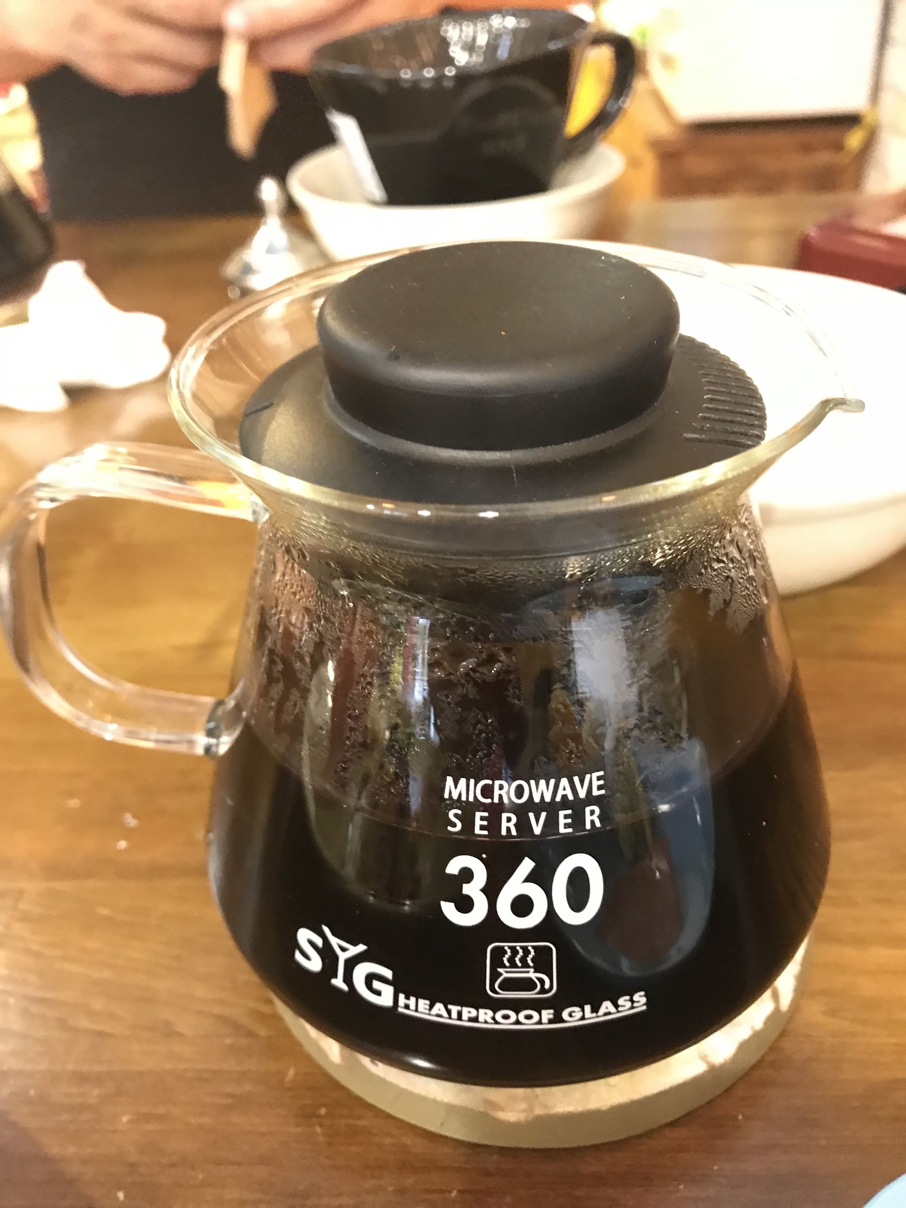 Un appareil de cuisson par micro-ondes doté d’un récipient en verre résistant à la chaleur, portant la mention « 360 SYG ».