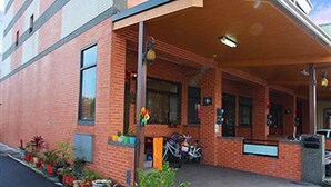 A building with a brick facade, a covered entrance, and a sign indicating a business or service. - Fish House Hostel (Wujie)