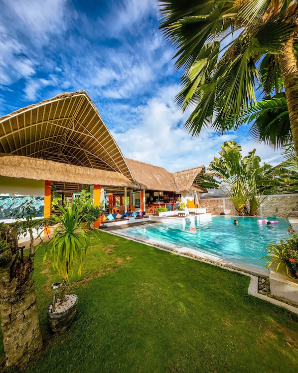 Een buitenzwembad, parasols bij het zwembad en ligstoelen