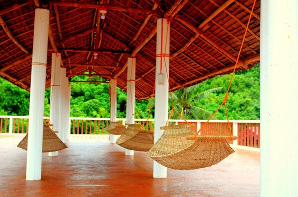 A covered outdoor area with white pillars and a thatched roof. - Oasis Resort and Spas (Boracay Island)