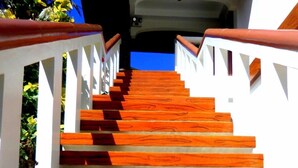 Una escalera con escalones de madera y barandillas blancas.