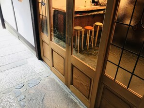 Een houten deur met glaspanelen en een vloer van stenen tegels.