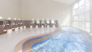 A large indoor swimming pool with multiple lanes, surrounded by a tiled wall and a glass enclosure. - Urabandai Grandeco Tokyu Hotel (Kitashiobara)