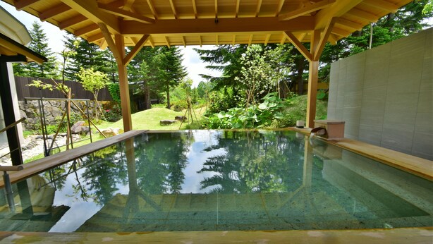 A clear swimming pool with a wooden deck and a pergola overhead. - Urabandai Grandeco Tokyu Hotel (Kitashiobara)