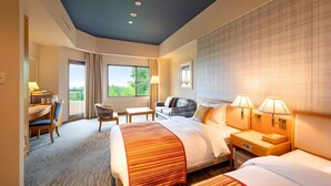 A hotel room with a large bed, a desk with a chair, a sofa, and two bedside tables with lamps. - Urabandai Grandeco Tokyu Hotel (Kitashiobara)