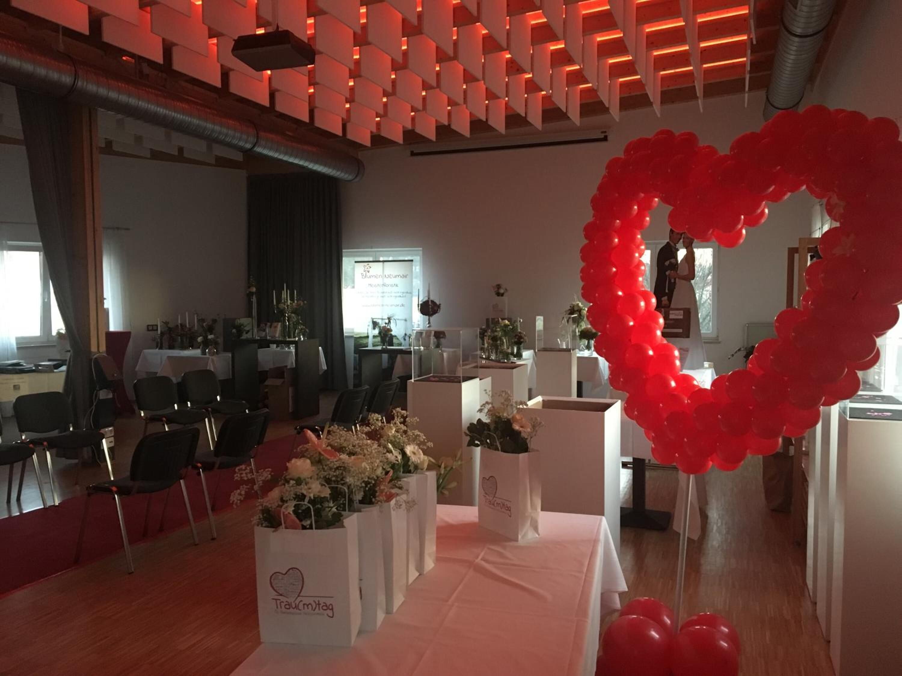 A conference room with a white table, chairs, and a heart-shaped balloon decoration.