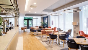 Un restaurant moderne doté d’un long comptoir, de nombreuses tables et de chaises.