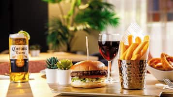 A meal with a burger, fries, and a drink on a wooden table.