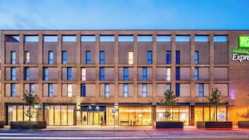 A Holiday Inn Express hotel with a modern brick facade, large windows, and a well-lit entrance.