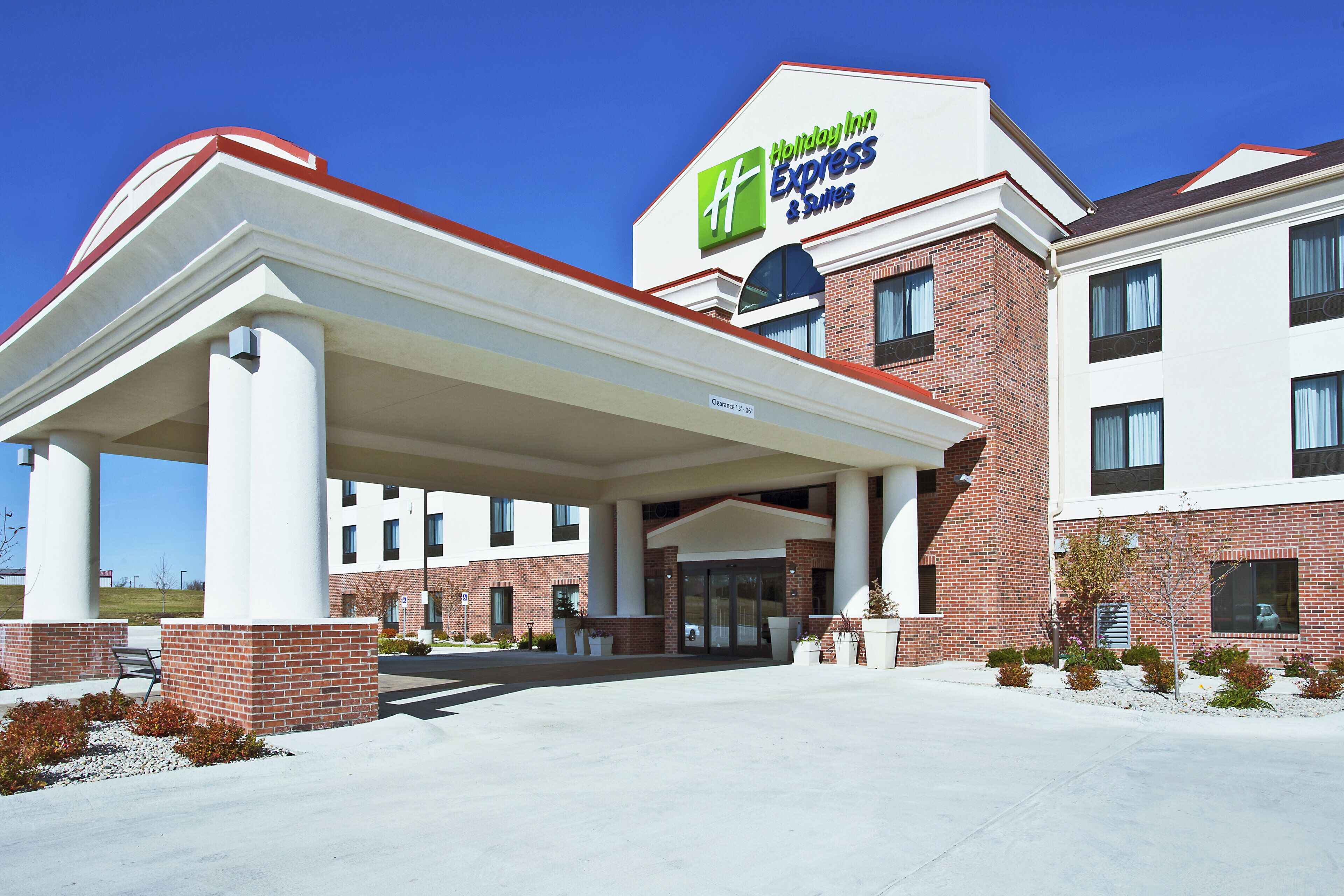 Un hôtel Holiday Inn Express & Suites doté d’un parking couvert et d’une façade en briques.
