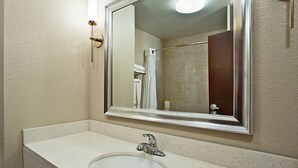 A bathroom with a white sink, a mirror, and a shower area. - Holiday Inn Express & Suites Springfield - Dayton Area by IHG (Springfield)