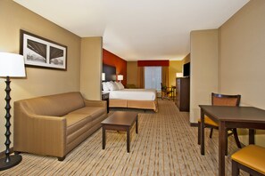 A hotel room with a bed, a sofa, a table, a TV, and a desk with a chair. - Holiday Inn Express & Suites Springfield - Dayton Area by IHG (Springfield)