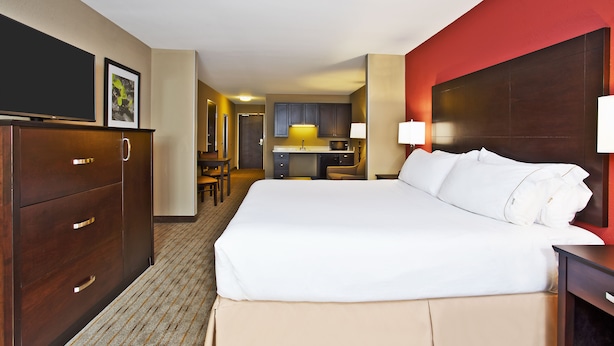A hotel room with a large bed, a desk, a chair, a TV, and a kitchenette. - Holiday Inn Express & Suites Springfield - Dayton Area by IHG (Springfield)