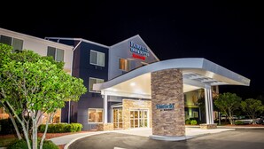 A Marriott Fairfield hotel with a modern design, featuring a stone pillar with the hotel name, a covered entrance, and a well-maintained outdoor area with trees and shrubs. - Fairfield Inn & Suites Fredericksburg (Fredericksburg)