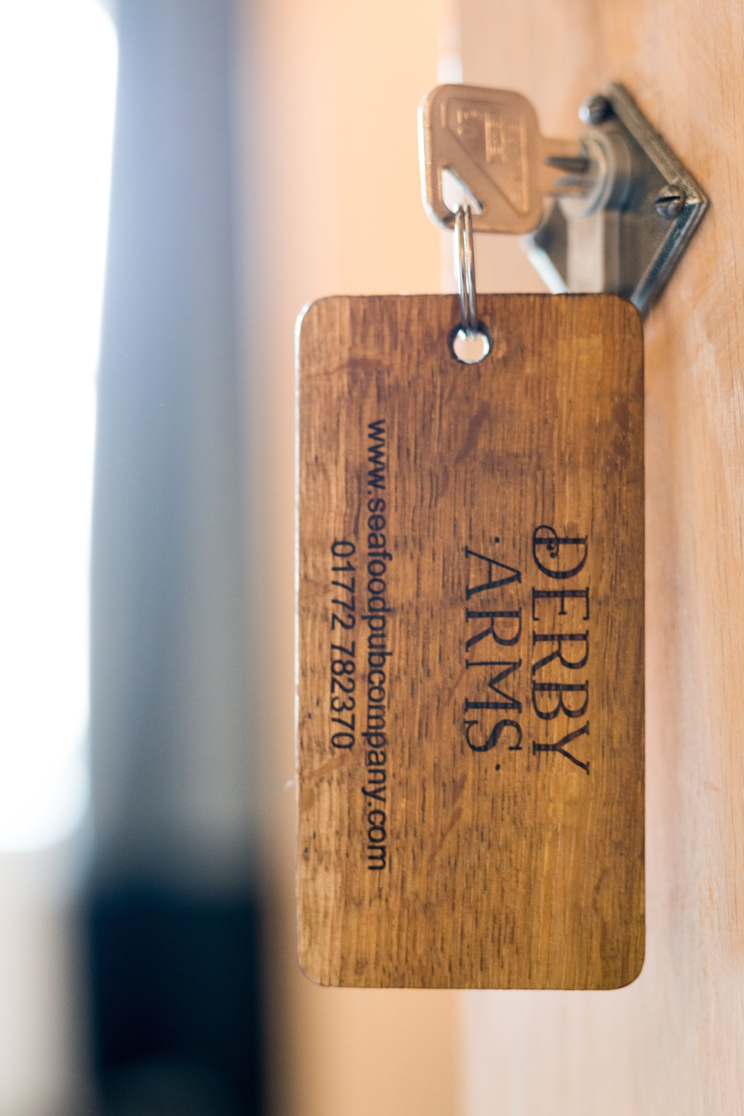 A wooden plaque with engraved text and a keyhole, likely a part of a door or cabinet.