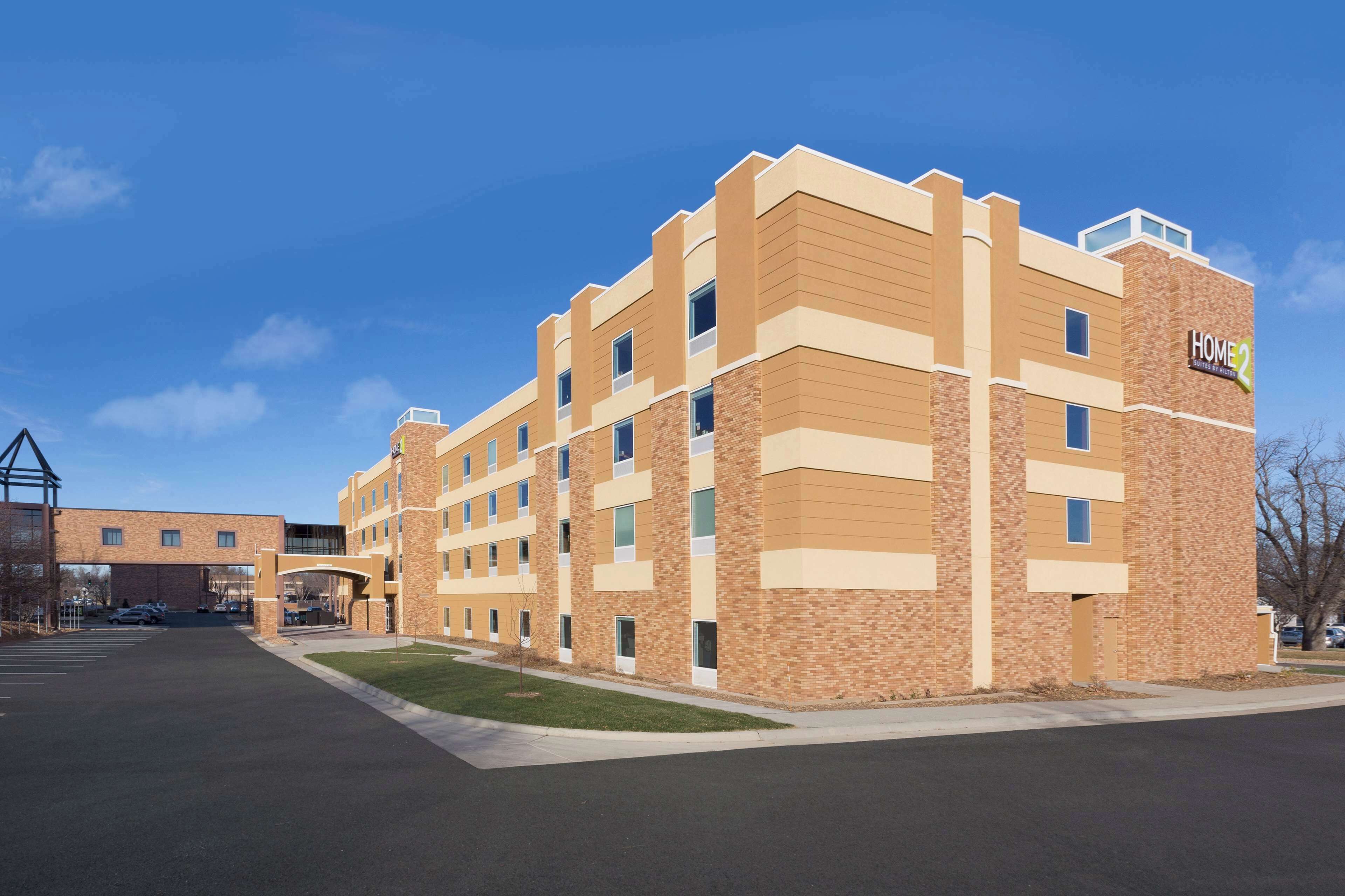A multi-story hotel with a brick facade and a sign reading "Home2".