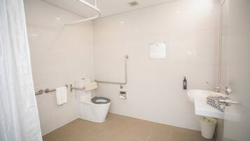 A bathroom with a toilet, sink, and shower.