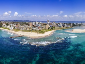 A coastal cityscape with a beachfront, buildings, and clear blue waters. - ibis Styles The Entrance (Long Jetty)