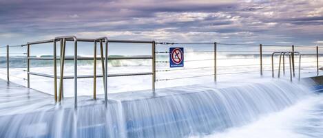A coastal walkway with metal railings and a 'No Diving Allowed' sign.