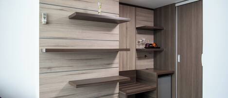 Une cuisine moderne dotée d’étagères en bois intégrées, d’un petit réfrigérateur et d’un meuble de rangement.