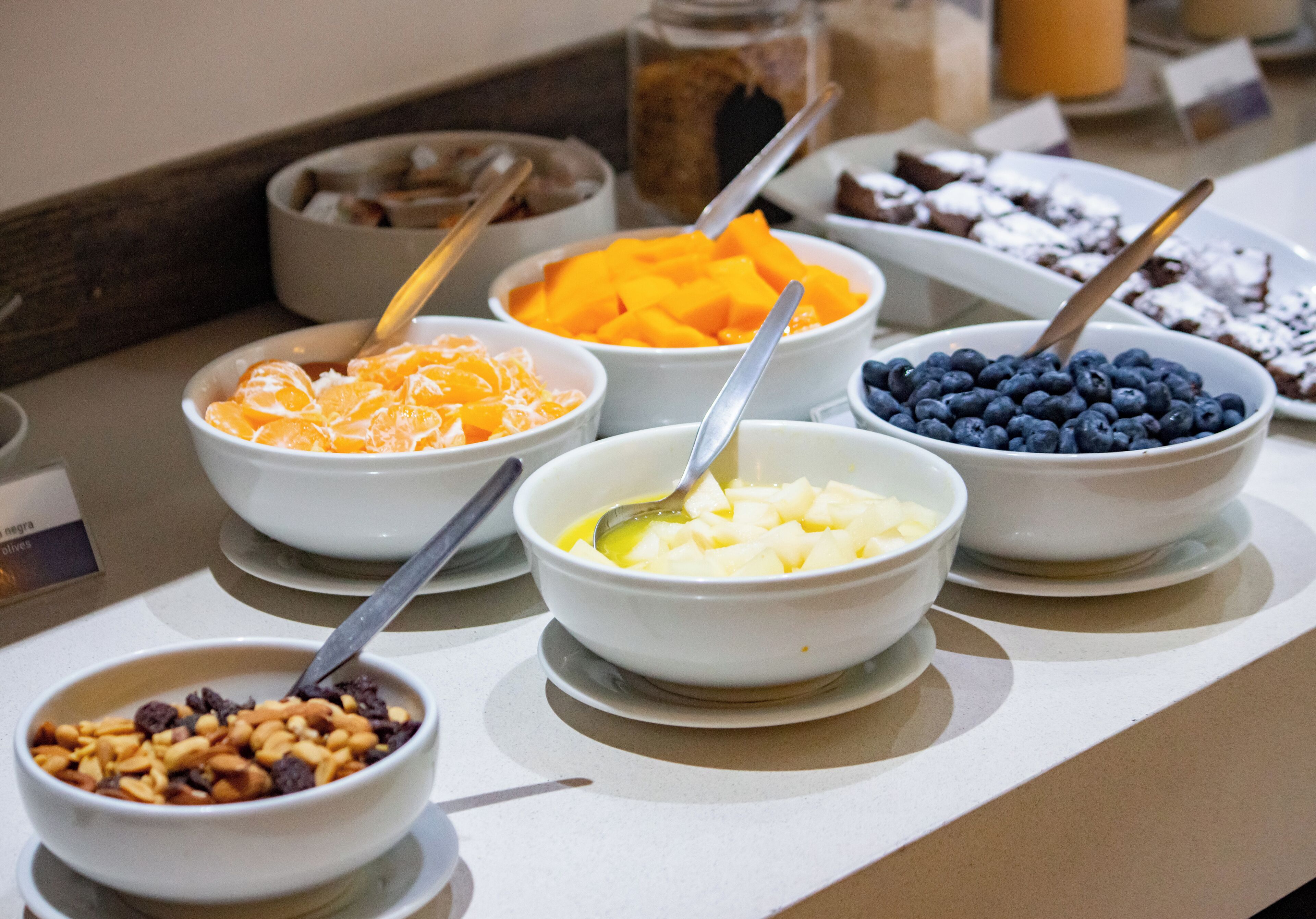 Ein Frühstücksbuffet mit verschiedenen Schalen Obst und Müsli.