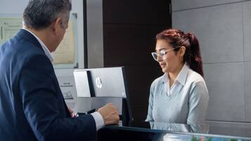 Un hombre y una mujer de pie frente a un portátil HP en una oficina moderna.