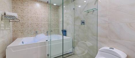 A modern bathroom with a glass-enclosed shower, a standalone bathtub, and a toilet.