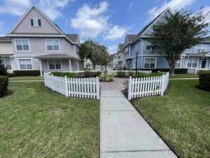 A residential street with houses, white picket fences, and a clear sky. - Orlando Select Vacation Homes (Kissimmee)