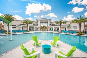 A pool area with a central fountain, surrounded by lounge chairs and palm trees. - Orlando Select Vacation Homes (Kissimmee)