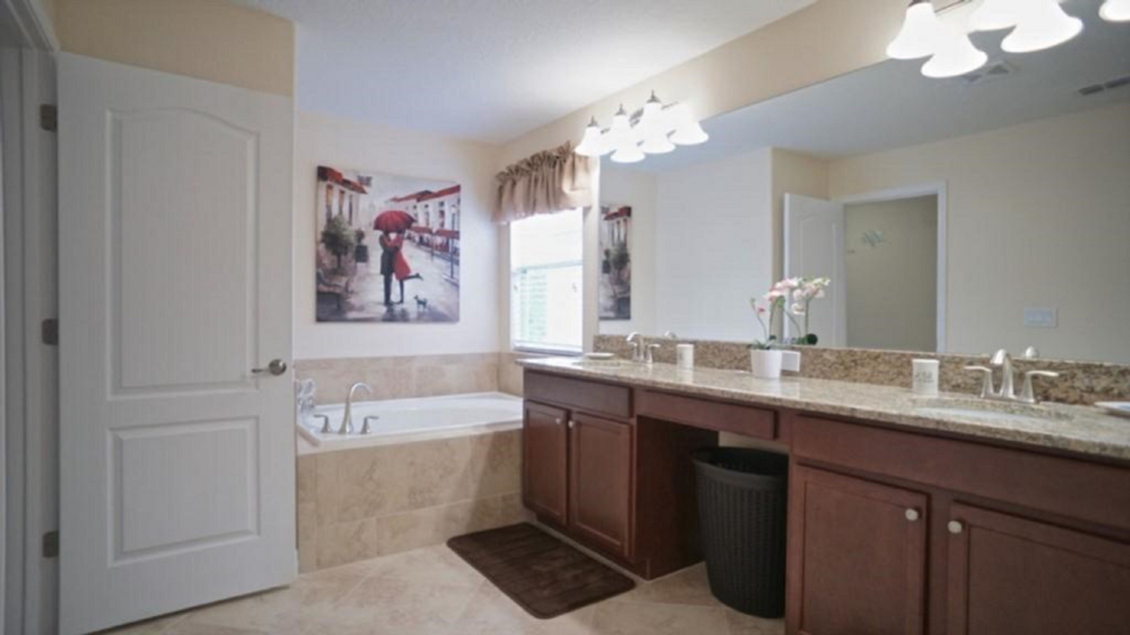 A bathroom with a double sink, a large mirror, and a painting of a couple on a street.