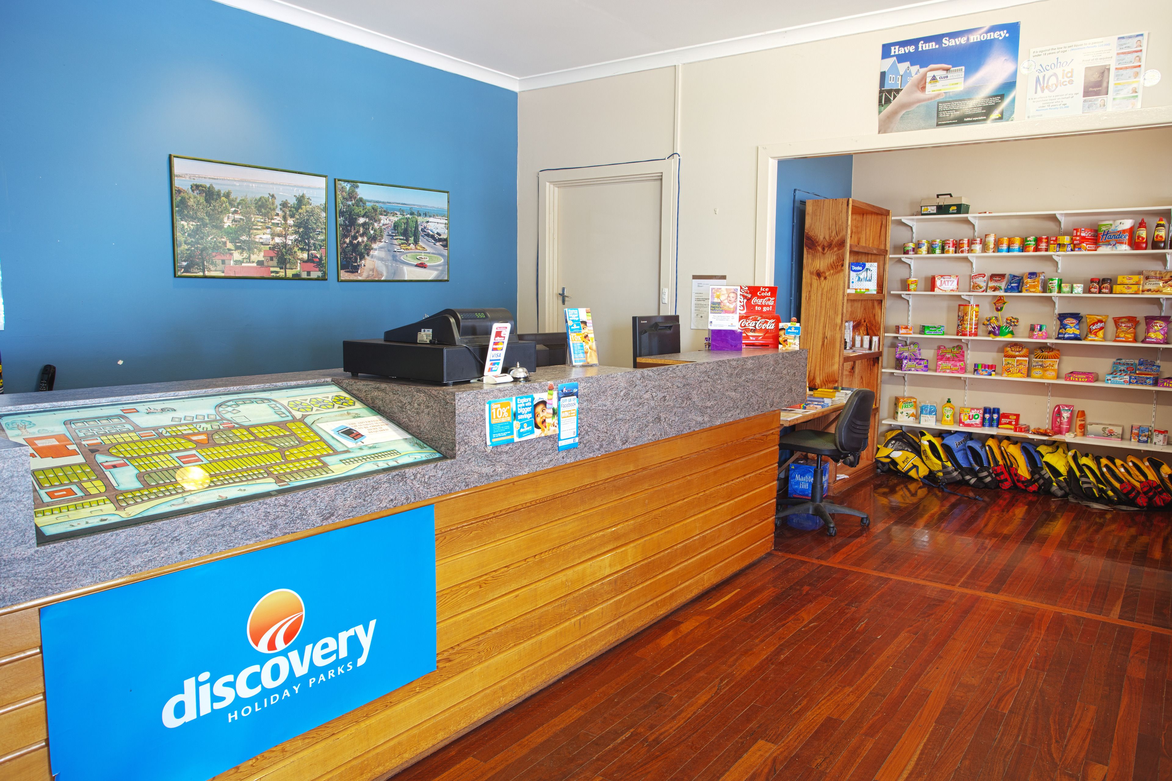 A reception area with a counter, a map display, and a Coca-Cola refrigerator.