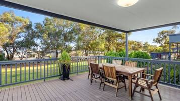 Enjoy dining al fresco in this serene outdoor space with a deck and lawn views.