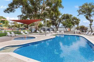 Una piscina al aire libre, sillones reclinables de piscina