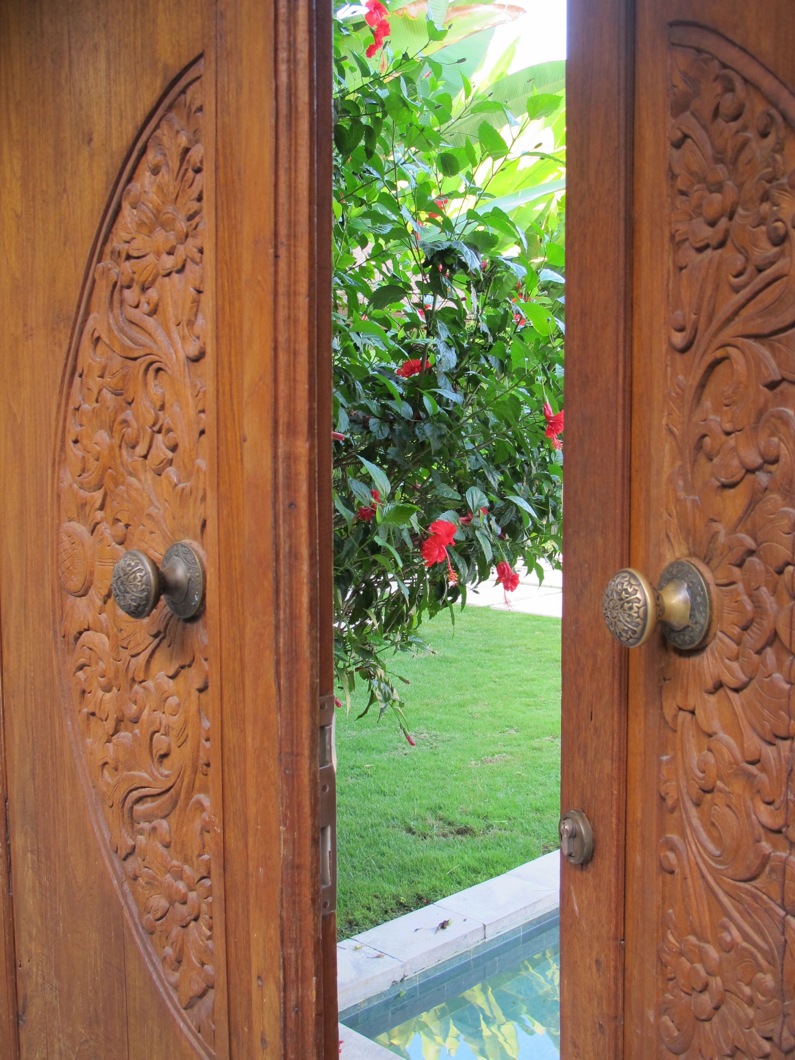 A wooden door with intricate carvings and a brass doorknob.