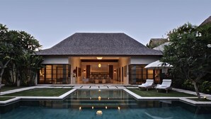 A modern house with a swimming pool, a well-maintained garden, and a large open living area. - Nyaman Villas (Seminyak)