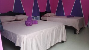 Habitación triple básica, varias camas, vista a la ciudad | Muebles diferentes, cortinas blackout y tabla de planchar con plancha