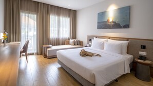 Habitación de hotel con dos camas, un escritorio y una silla.