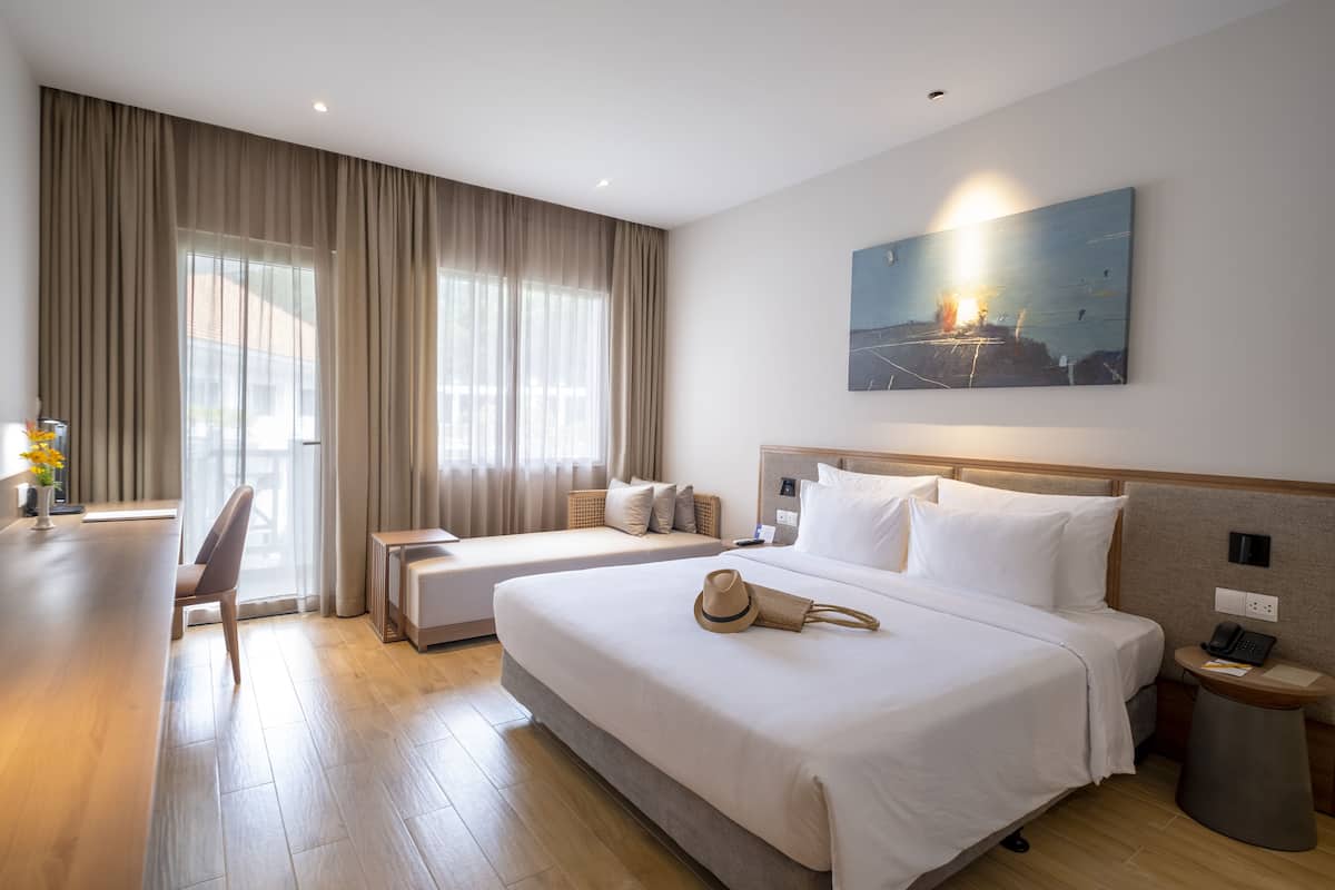 Habitación de hotel con dos camas, un escritorio y una silla.
