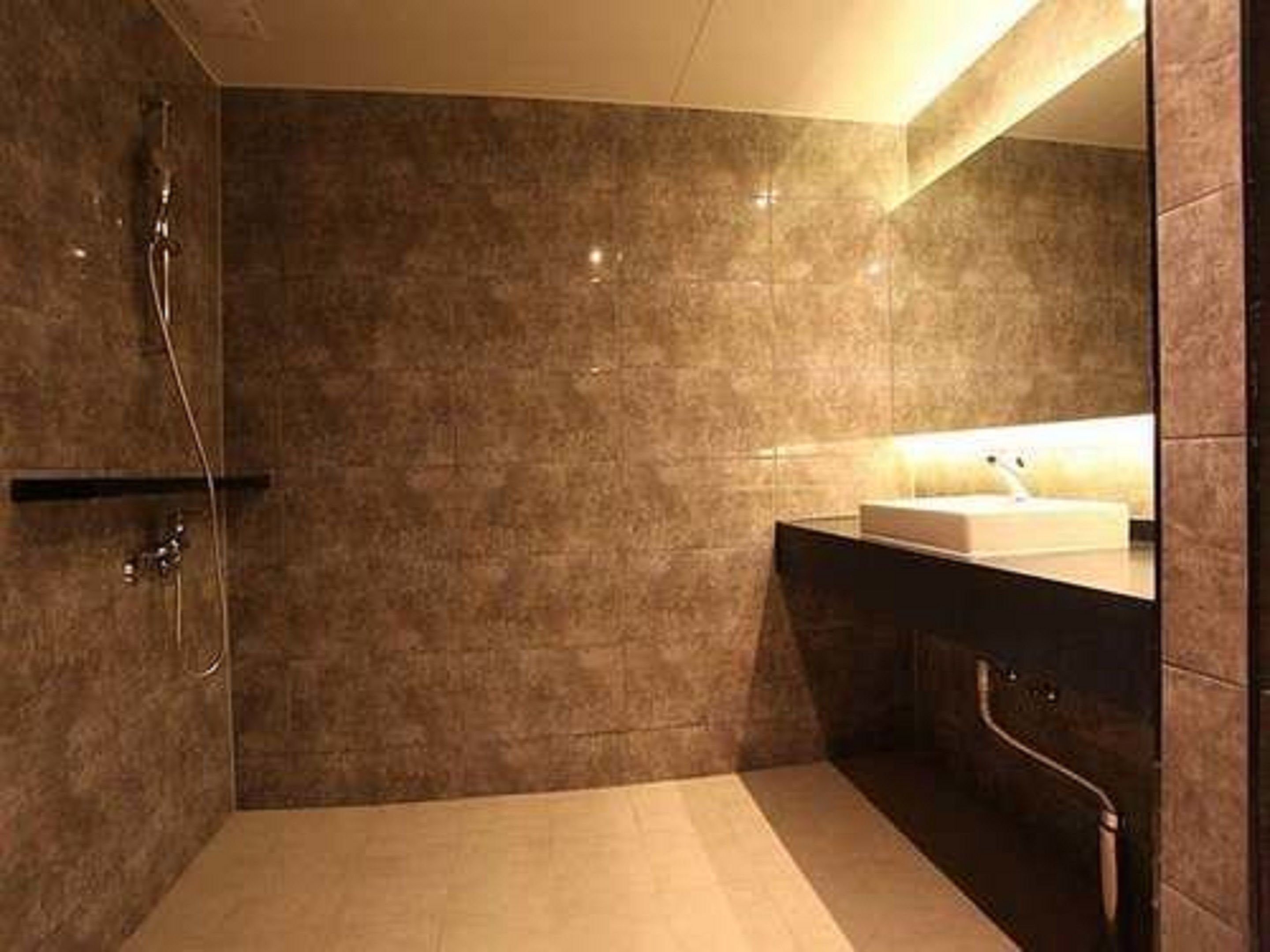Un bagno moderno con doccia, lavabo e specchio.