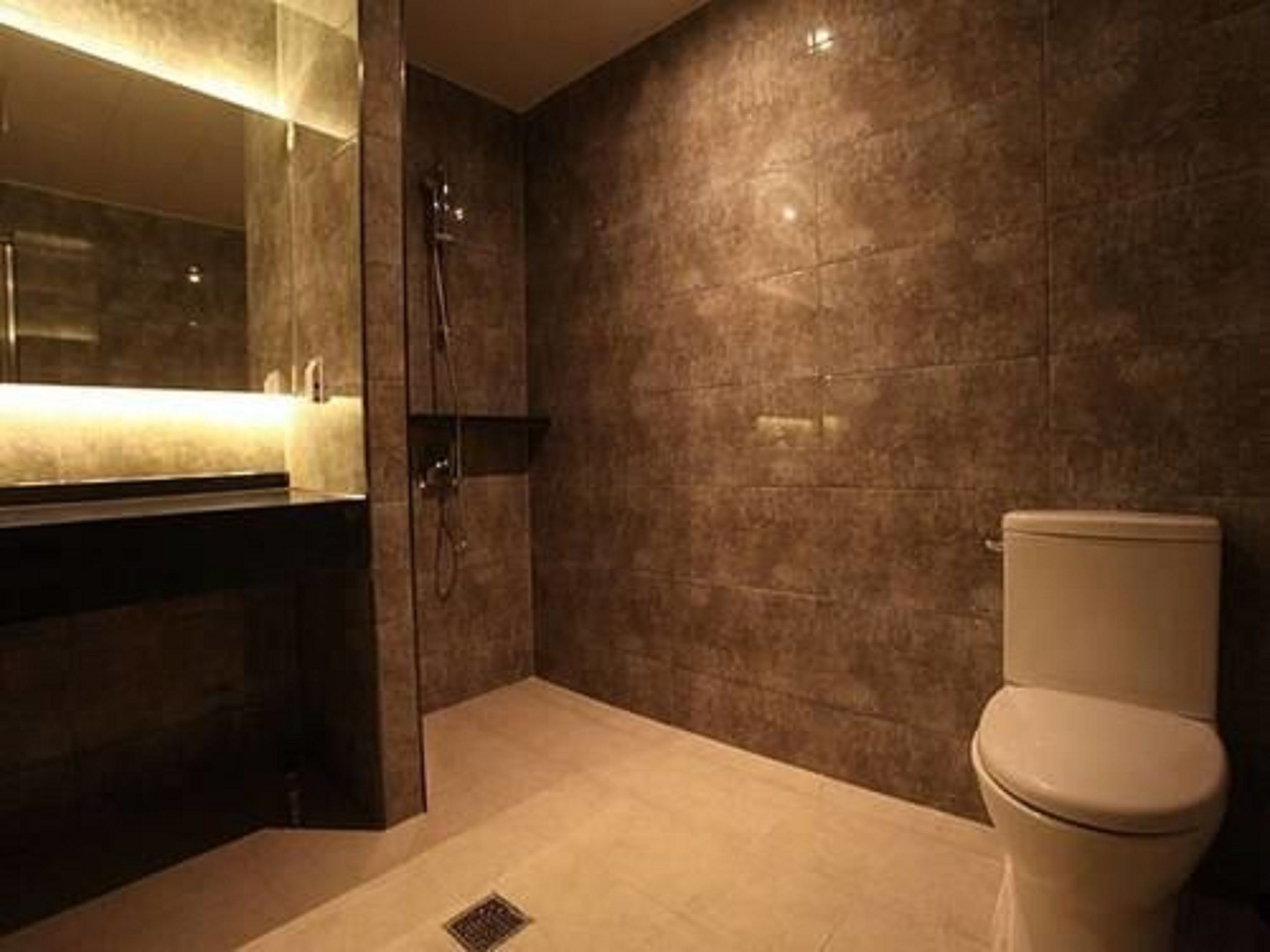A bathroom with a toilet, a shower, and a sink.