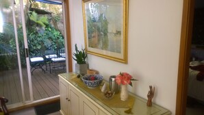 A room with a glass door leading to an outdoor area with a table and chairs. - Linley House (Linley Point)